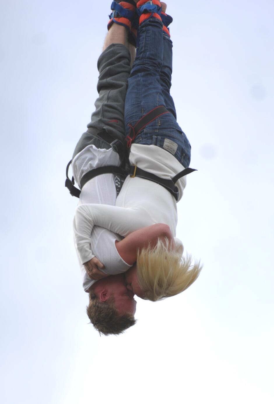 Two people strapped together on a tandem bungee jump with UK Bungee Club